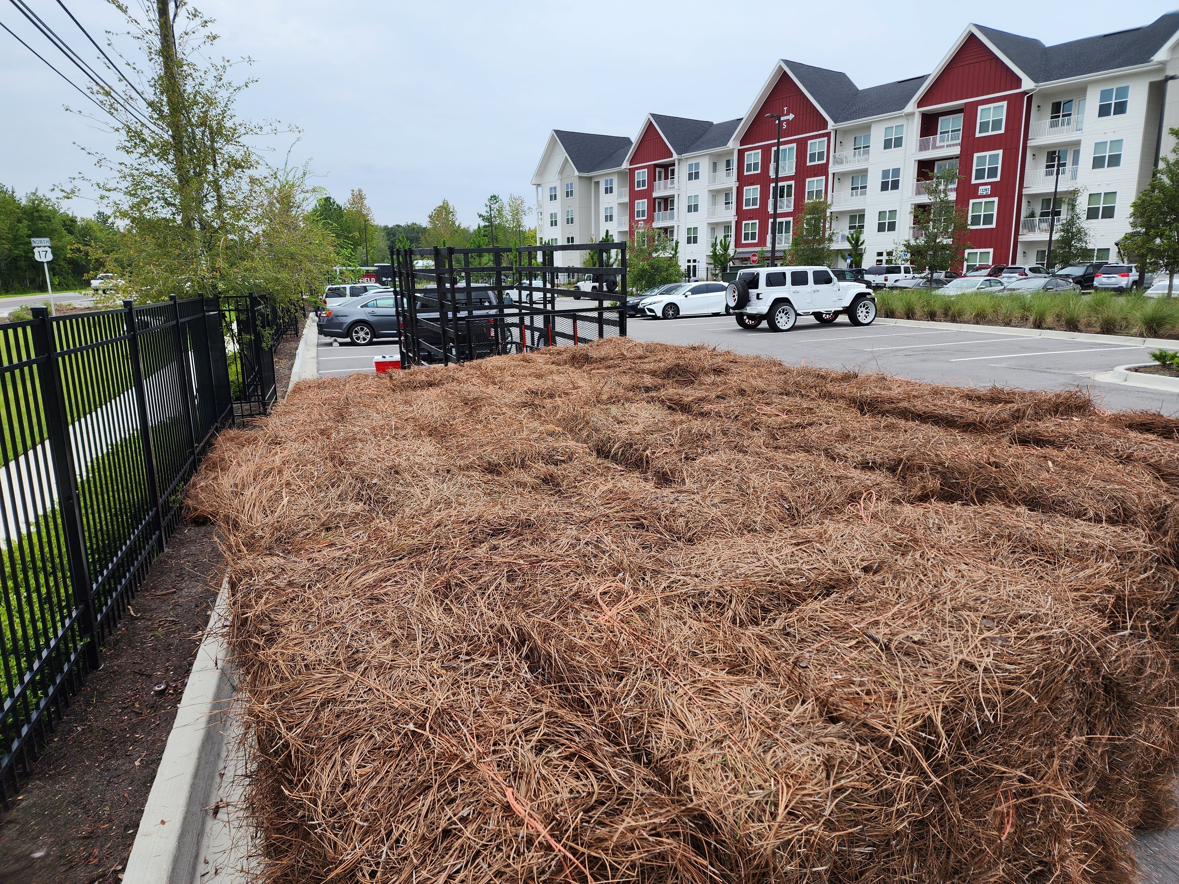 400 bales of premium longleaf pine straw staged for installation at an apartment complex.